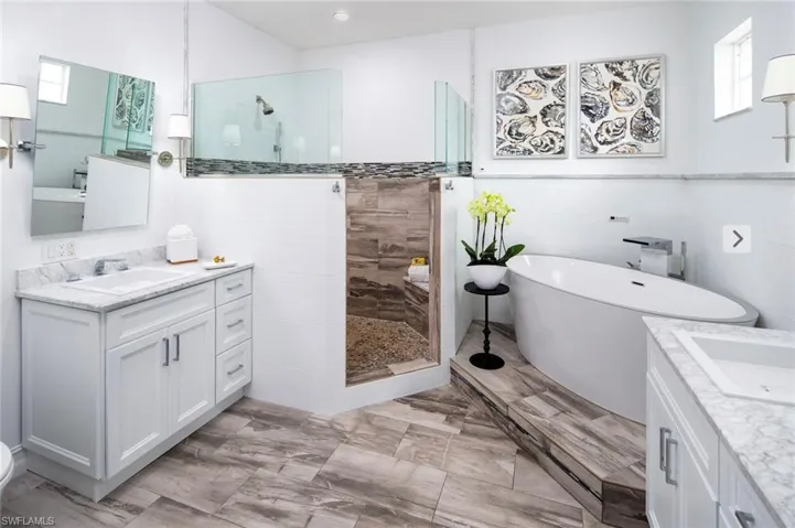 Full bath featuring vanity, a walk in shower, and marble finish floors