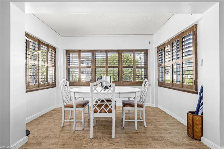 Wood-finish flooring throughout, complemented by white walls and wood plantation shutters