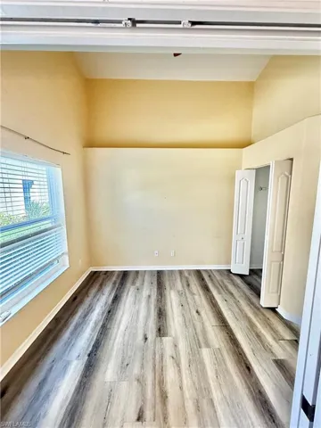 Spare room featuring light wood finished floors and lofted ceiling