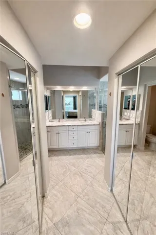 Full bathroom with double vanity and a stall shower