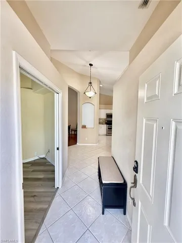 Foyer with light tile patterned floors and baseboards