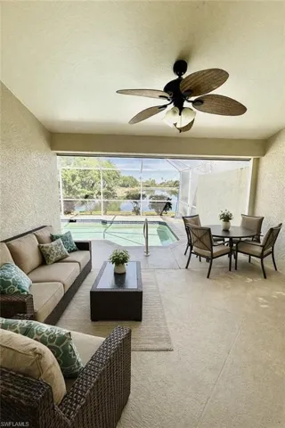 Lanai with outdoor lounge area, ceiling fan, and a pool