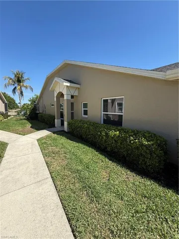 View of front facade with a front yard and stucco siding