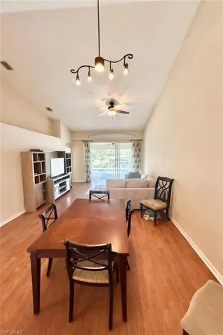 Dining area with light wood-style floors, a ceiling fan, and lofted ceiling