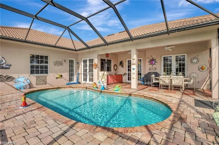 Pool featuring a lanai, ceiling fan, french doors, and a patio area
