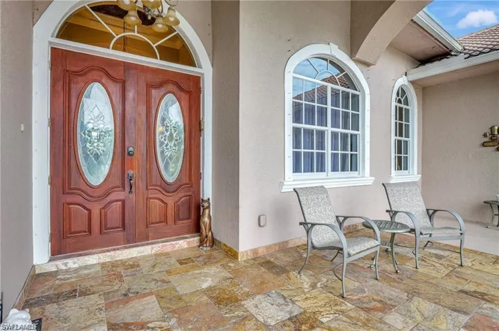 Doorway to property featuring stucco siding