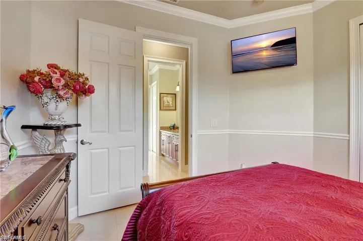 Bedroom with light tile patterned flooring and ornamental molding