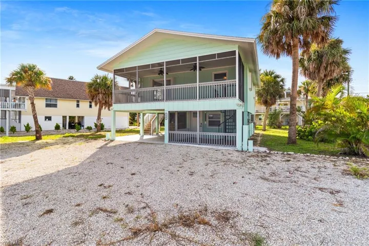 Front of house with a ceiling fan, driveway, a carport, and stairway