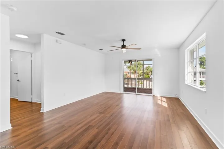 Empty room featuring dark wood-style floors and ceiling fan