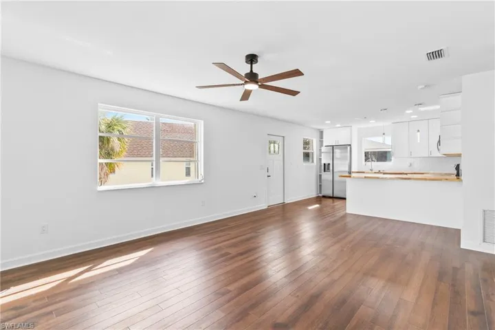 Unfurnished living room featuring dark wood-style floors, a ceiling fan, and recessed lighting