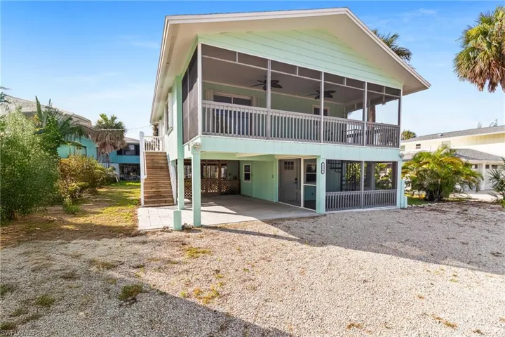 Front view of house featuring a carport, ceiling fan, stairway, a patio area, and driveway