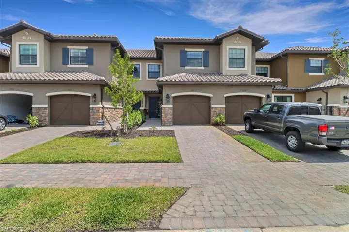View of front of home featuring stone siding, a tiled roof, and stucco siding