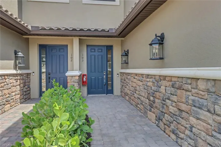 Entrance to property featuring stone siding and stucco siding