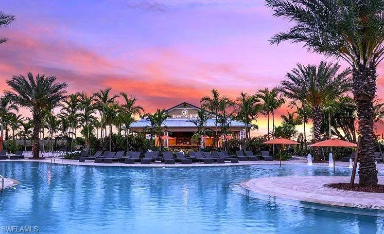 Pool at dusk featuring a community pool and a patio area