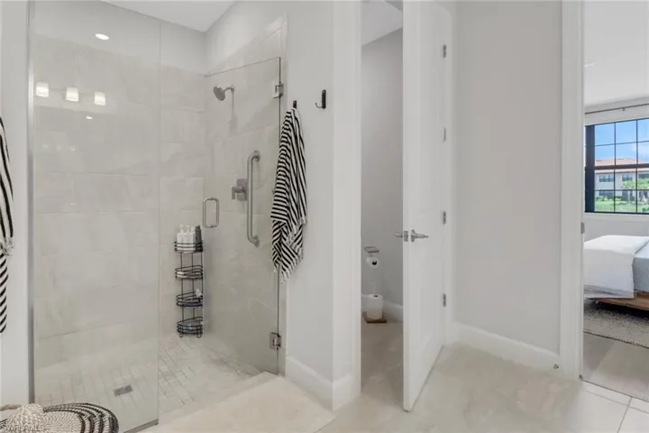 Full bathroom with connected bathroom, baseboards, tile patterned floors, and a stall shower