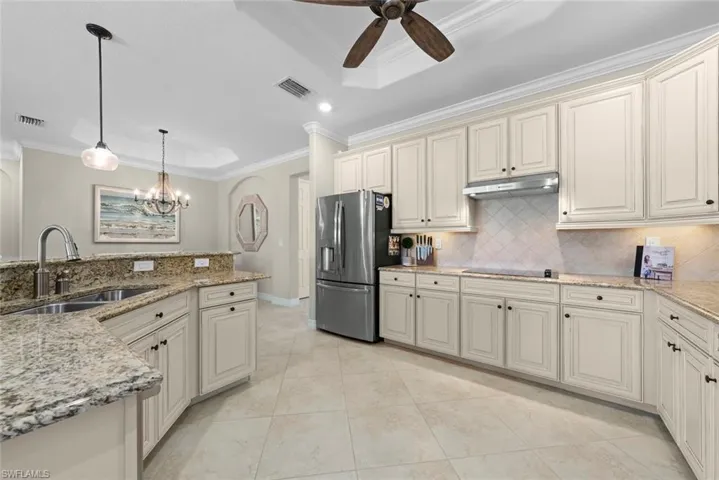 Kitchen featuring light-toned cabinetry, granite countertops, stainless steel appliances, a tiled backsplash, and recessed lighting