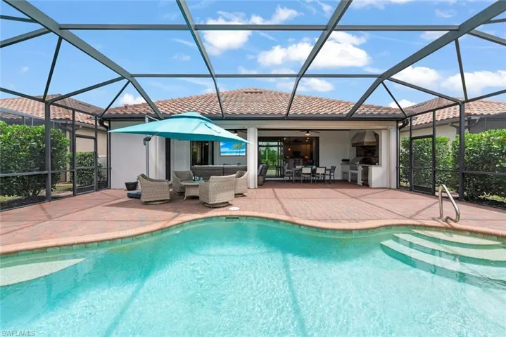 Pool home with outdoor seating, covered lanai space and outdoor kitchen