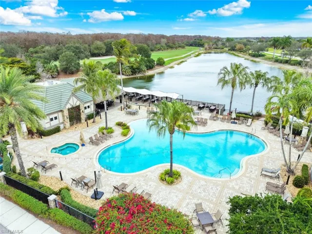 TwinEagles Resort-style pool area featuring a freeform swimming pool, integrated spa, and cabana bar