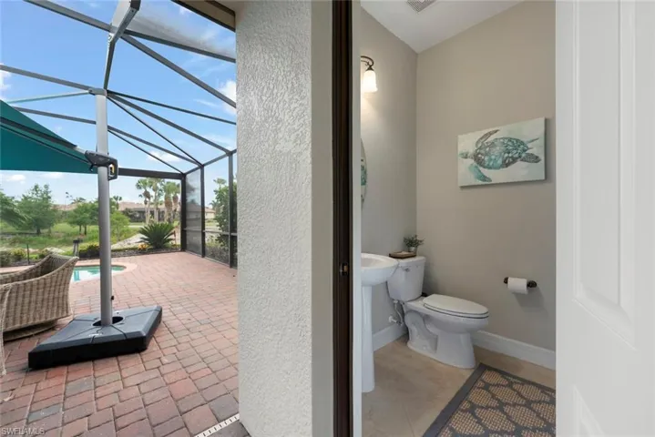 Air conditioned pool bath on the lanai with a sink and toilet.