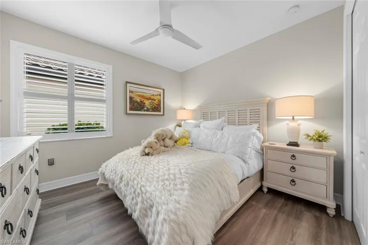 Guest bedroom with new vinyl flooring, contemporary ceiling fan, and a window with plantation shutters