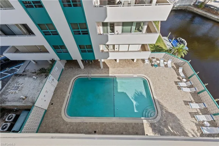 Community pool with a water view and a patio area
