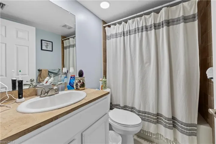 Full bath with vanity and shower / bath combination with curtain