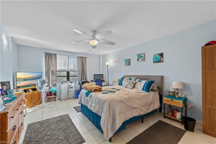 Bedroom featuring light tile patterned floors and ceiling fan
