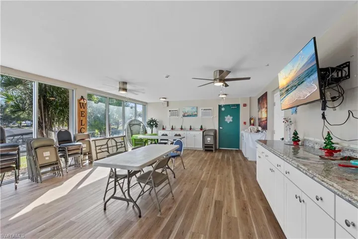 Dining room with ceiling fan, light wood-style floors, and an AC wall unit