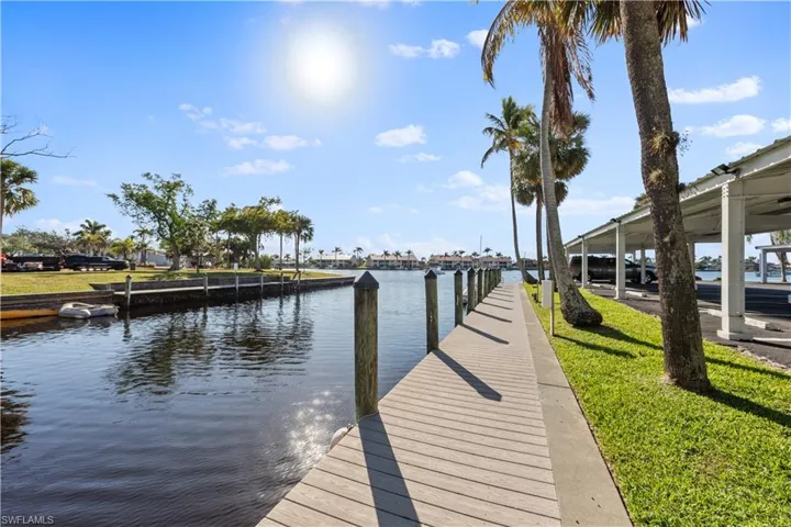 Dock area with a water view and a lawn