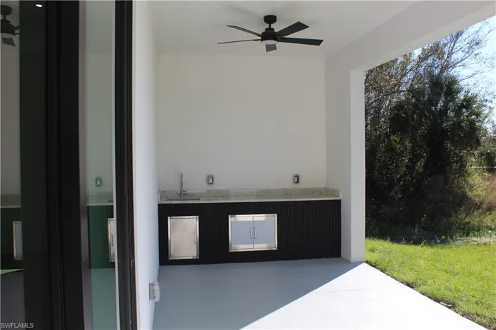 View of patio with a ceiling fan and a sink