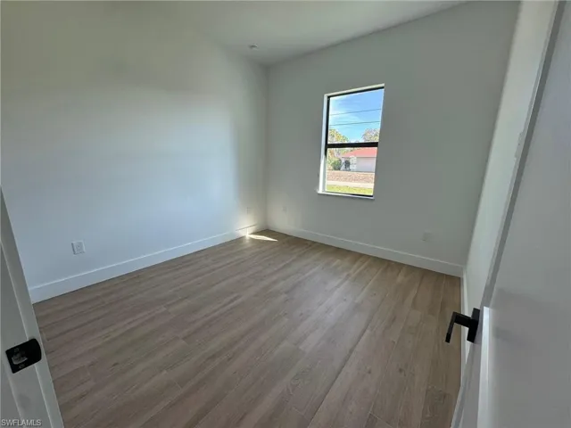 Spare room with light wood-type flooring and baseboards