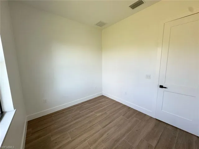Unfurnished room featuring dark wood-style flooring