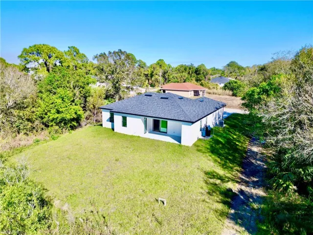 Aerial view of property and surrounding area with a tree filled landscape