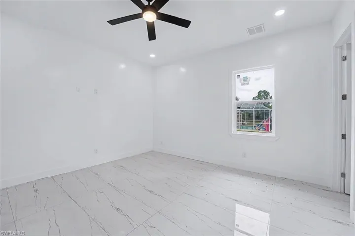 Bright interior space featuring white walls and large format tile flooring