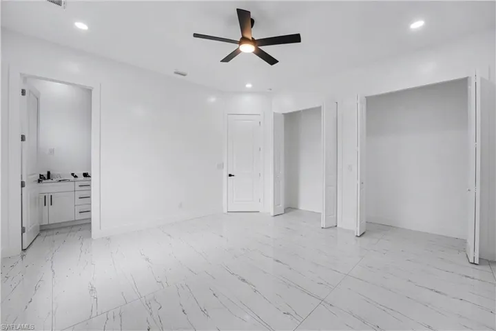 Spacious interior room featuring large format tile flooring, a ceiling fan with integrated lighting, and recessed ceiling lights