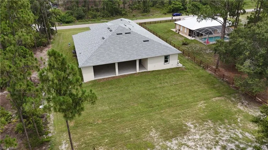 Expansive grass lawn with mature trees, offering a significant outdoor area