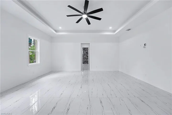 Spacious room featuring white walls and large-format porcelain tile flooring with a marble-effect pattern