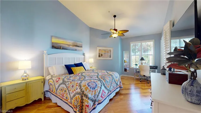 Primary Bedroom featuring light hardwood flooring, an office area, a ceiling fan, and vaulted ceiling