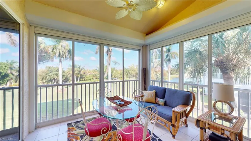 Sunroom with tile patterned floors, vaulted ceiling, and a water view