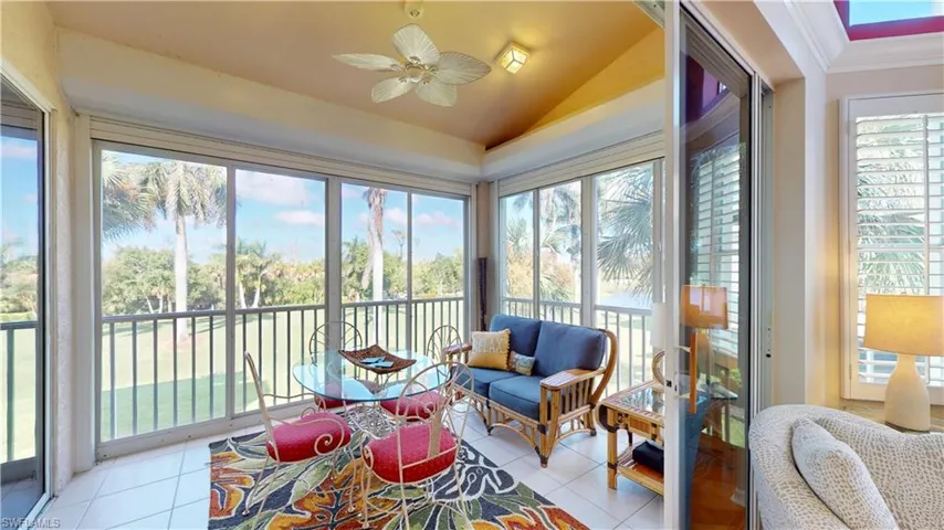Sunroom with lofted ceiling, plenty of natural light, tile patterned flooring, and crown molding
