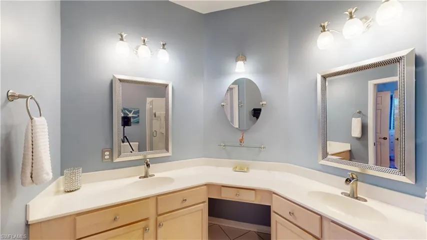 Primary Bathroom with double vanity, light tile patterned floors, and a shower