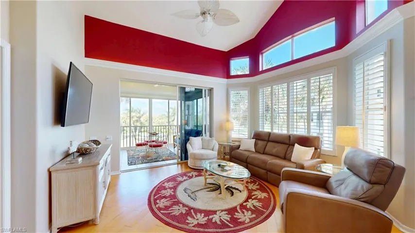 Living area featuring high vaulted ceiling, light hardwood floors, and ceiling fan