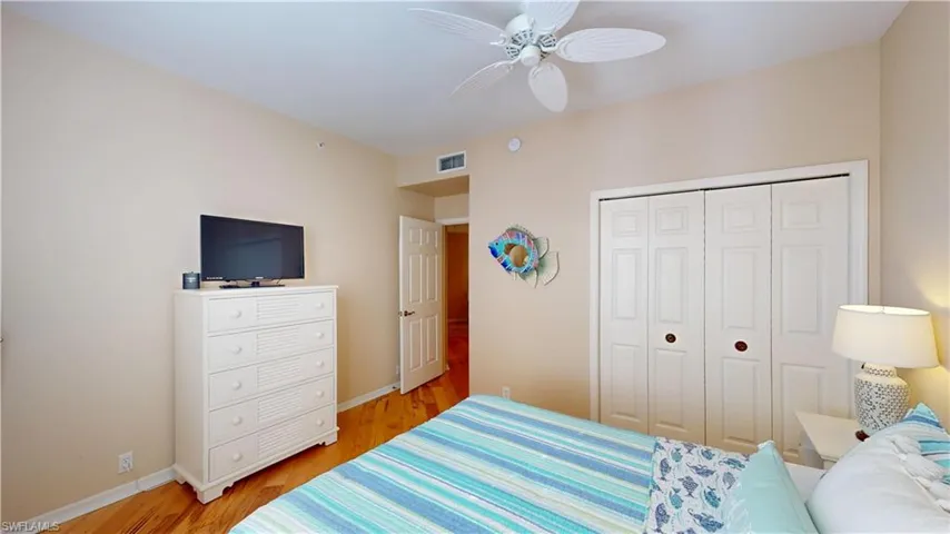 Bedroom featuring light hardwood floors, a ceiling fan, and a closet