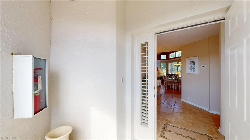 Hall with a textured wall and stone tile flooring
