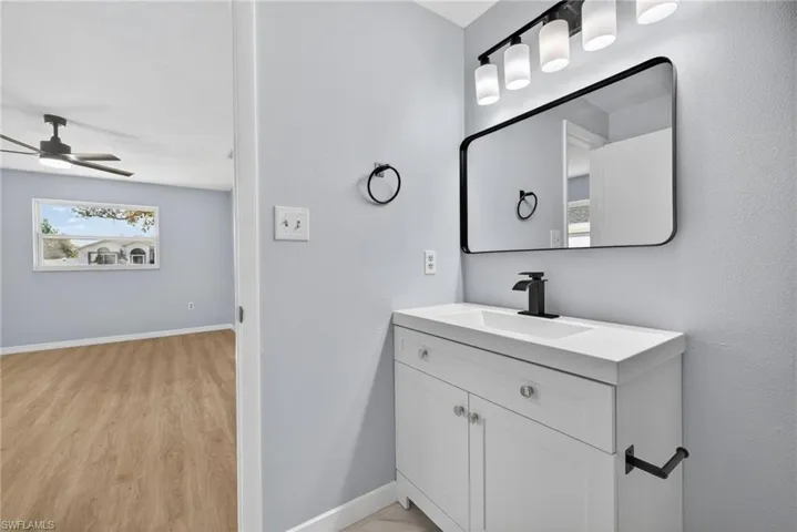 Bathroom featuring vanity, a ceiling fan, and light wood-type flooring