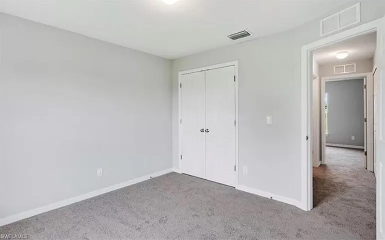 Unfurnished bedroom with carpet flooring and a closet