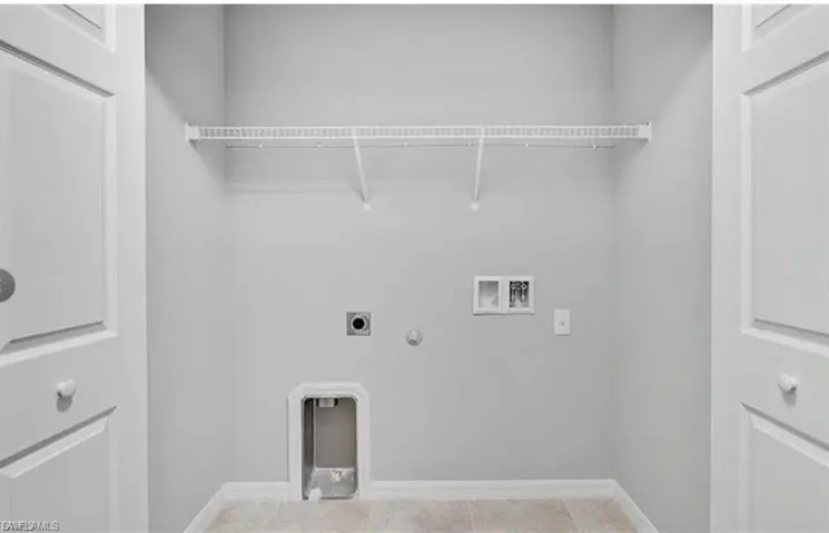 Laundry area with hookup for a gas dryer, washer hookup, hookup for an electric dryer, and light tile patterned floors
