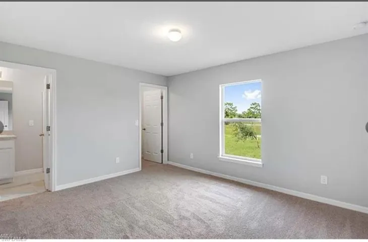 Unfurnished bedroom featuring light colored carpet and baseboards