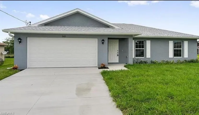 Ranch-style house with a front yard, a garage, stucco siding, driveway, and a shingled roof