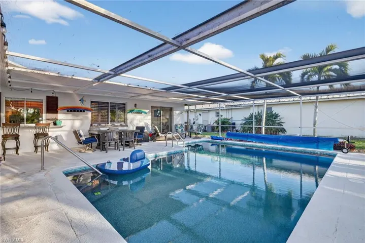 View of swimming pool featuring a covered pool, a lanai, a patio, and a sunroom